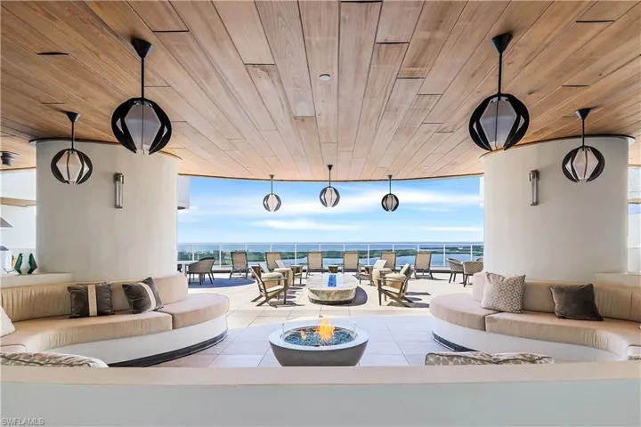 An upscale rooftop terrace features a fire element and hot tub, providing a refined space for outdoor relaxation and entertaining.