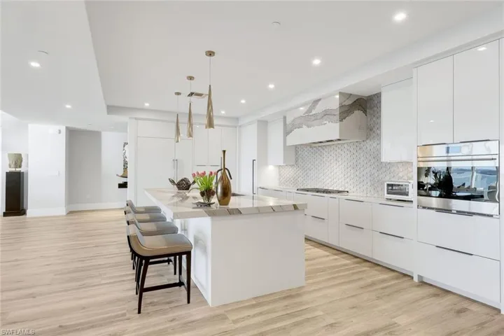 Sleek modern cabinetry, a custom backsplash, and bespoke lighting details define this sophisticated kitchen space.