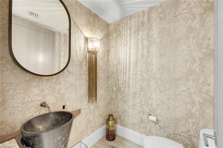 A refined powder room appointed with designer fixtures and elegant finishes.