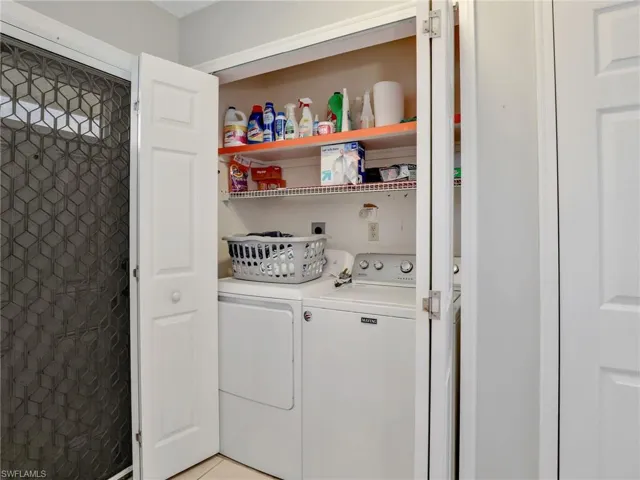 Laundry room featuring washing machine and dryer and light tile patterned floors