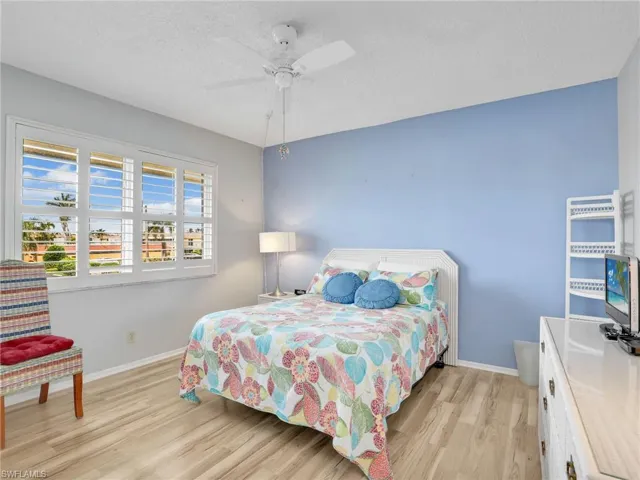 Bedroom featuring light wood finished floors, a textured ceiling, and a ceiling fan