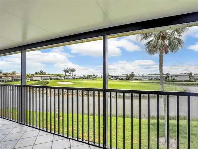 Unfurnished sunroom featuring golf course view, a residential view, and a water view