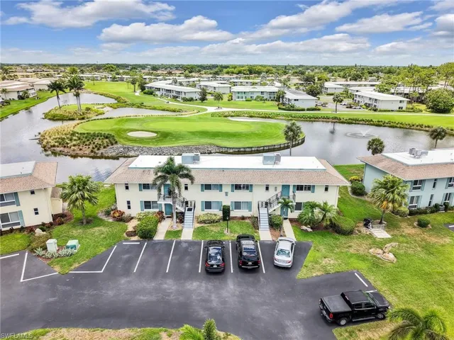 Aerial view of residential area with a golf club and a nearby body of water