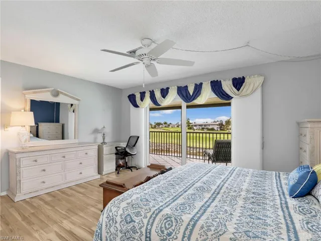 Bedroom featuring access to outside, light wood-style flooring, a ceiling fan, and a textured ceiling