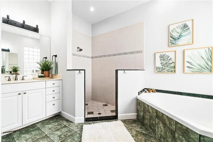 Bathroom featuring tile flooring, separate shower and tub, and vanity