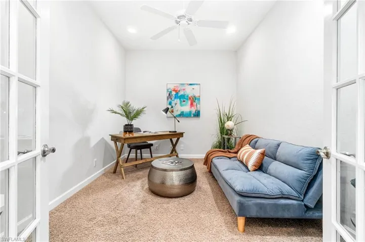 Living area with carpet flooring, ceiling fan, and french doors