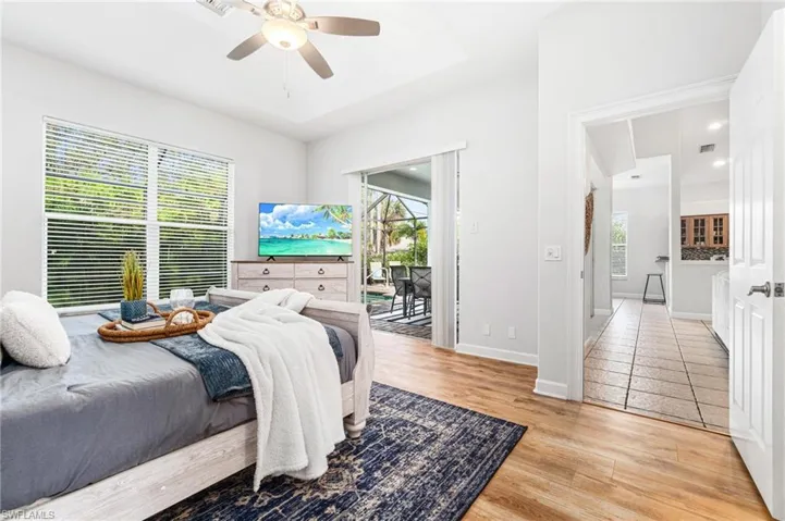 Tiled bedroom with ceiling fan, access to exterior, and multiple windows
