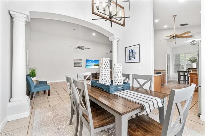 Dining space featuring light tile flooring and ceiling fan with notable chandelier