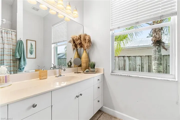 Bathroom featuring a healthy amount of sunlight, tile flooring, and vanity