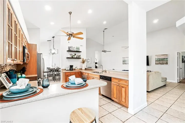Kitchen with sink, light tile flooring, ceiling fan, and stainless steel appliances