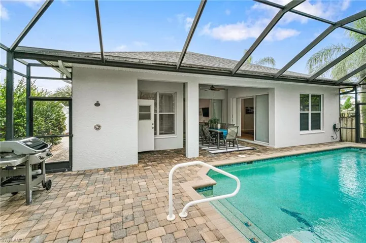 View of pool with ceiling fan, a lanai, a patio area, and area for grilling