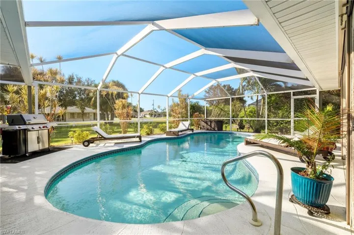 View of pool with a patio, grilling area, and a lanai