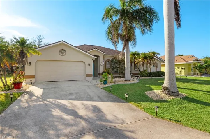 View of front of property with a garage and a front lawn