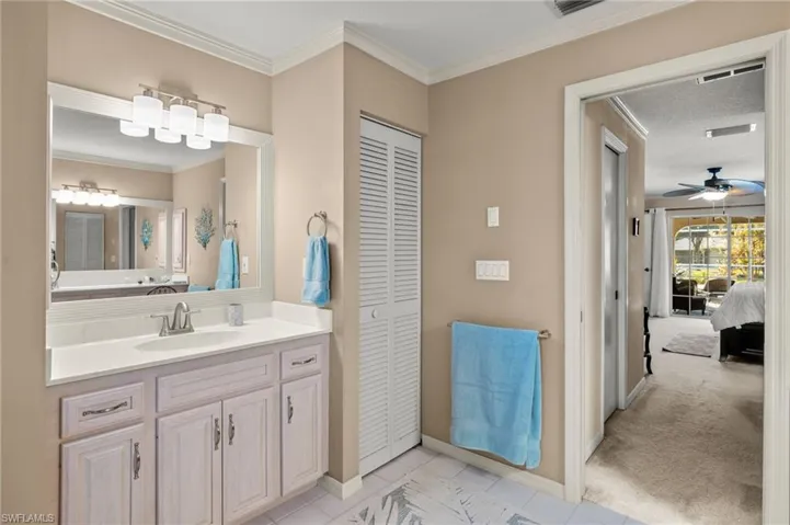 Bathroom featuring ceiling fan, vanity, and crown molding