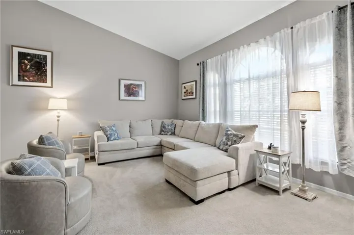 Living room featuring carpet floors and vaulted ceiling