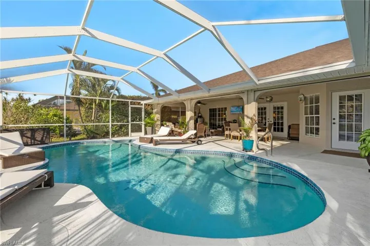 View of swimming pool with a lanai and a patio area
