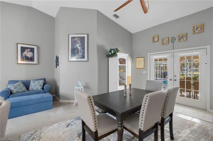 Carpeted dining space featuring french doors, high vaulted ceiling, and ceiling fan