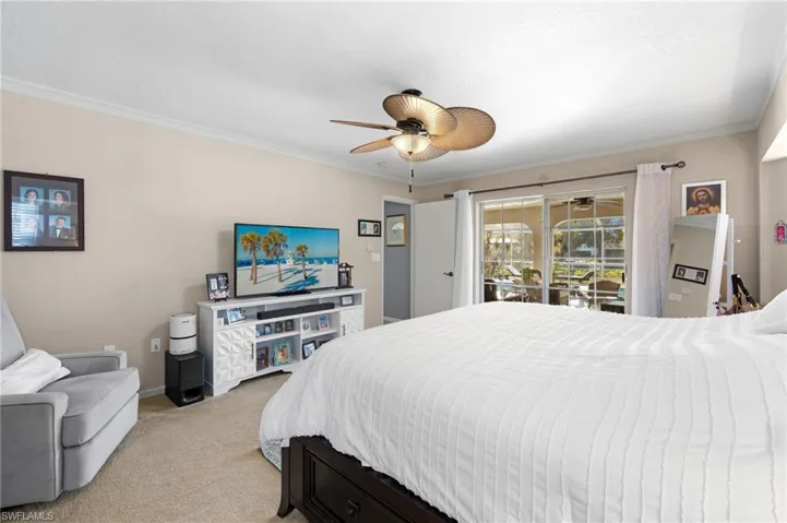 Carpeted bedroom with ornamental molding, access to exterior, and ceiling fan