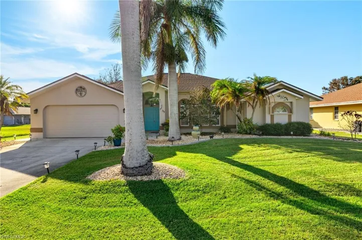 Ranch-style home featuring a garage and a front lawn