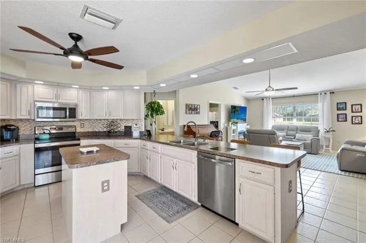 Kitchen with white cabinets, stainless steel appliances, sink, and a kitchen island