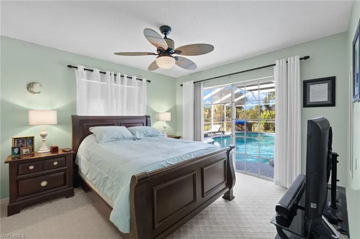 Carpeted bedroom with a textured ceiling, ceiling fan, and access to outside