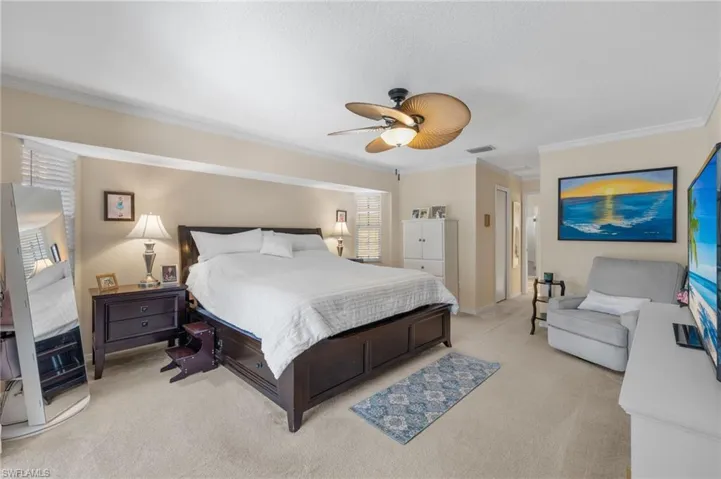 Bedroom featuring crown molding, ceiling fan, and light colored carpet