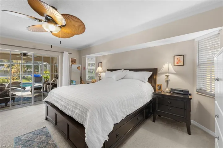 Carpeted bedroom with ceiling fan, ornamental molding, and access to exterior