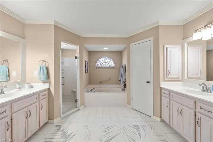 Bathroom featuring crown molding, vanity, and shower with separate bathtub