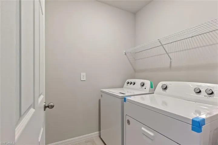 Laundry area featuring baseboards and washing machine and dryer