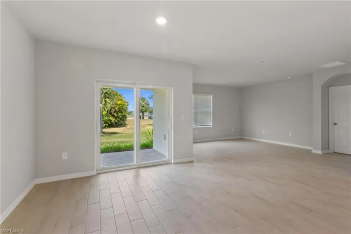 Spare room with wood tiled floors, recessed lighting, and arched walkways
