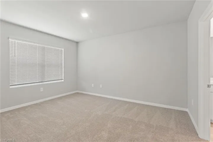 Unfurnished room featuring baseboards and light colored carpet