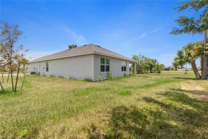 View of home's exterior with stucco siding and a lawn