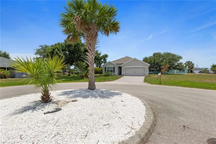 Ranch-style house featuring a front lawn and curved driveway