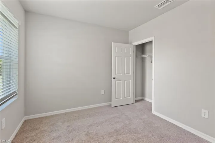 Unfurnished bedroom featuring light colored carpet and a closet