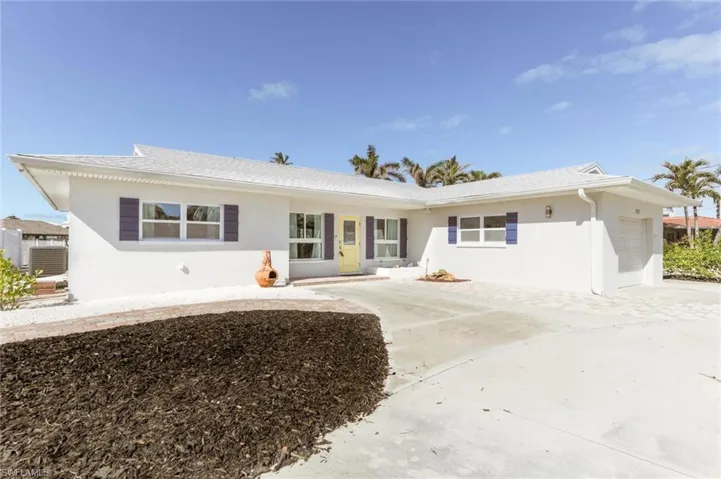 View of front facade featuring a garage, concrete driveway, and stucco siding