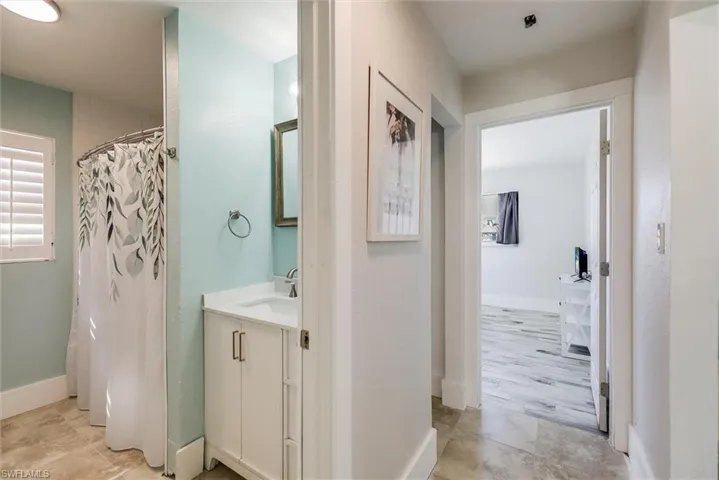 Bathroom featuring curtained shower, vanity, and baseboards