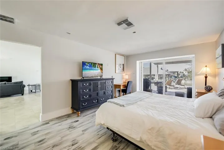 Bedroom with access to exterior, baseboards, visible vents, and light wood-style floors