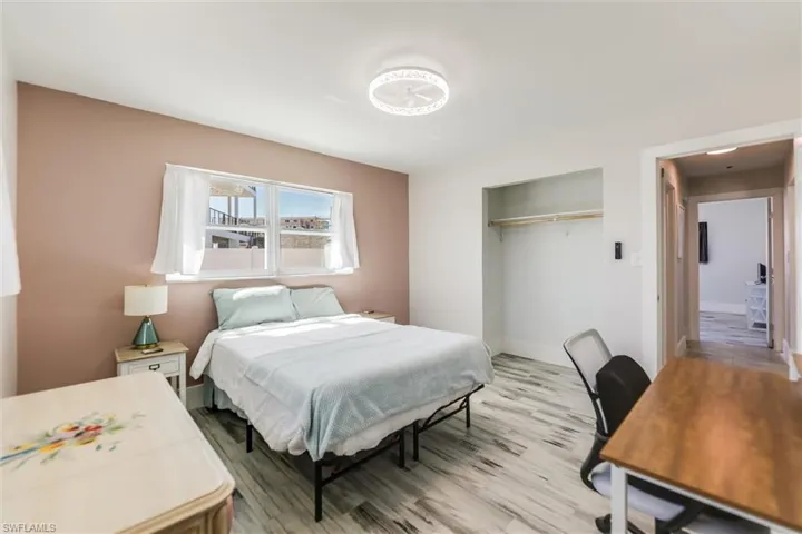 Bedroom with a closet, light wood-style flooring, and baseboards