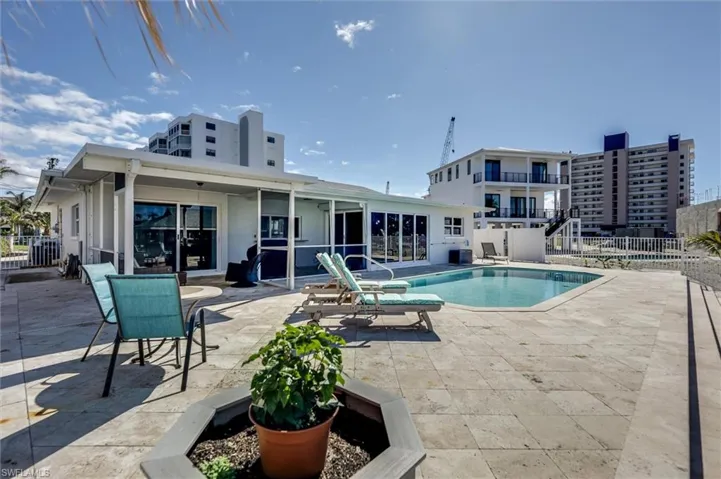 Community pool featuring a patio area and fence