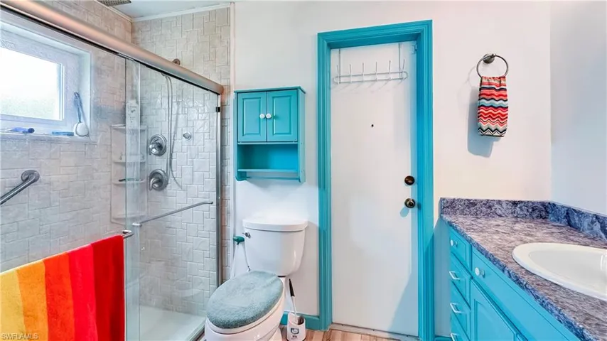 Bathroom with an enclosed shower, toilet, and vanity