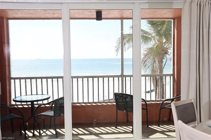 Sunroom / solarium featuring a water view and a beach view