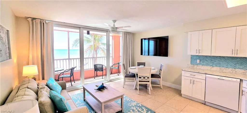 Living room featuring a water view, ceiling fan, and light tile patterned flooring