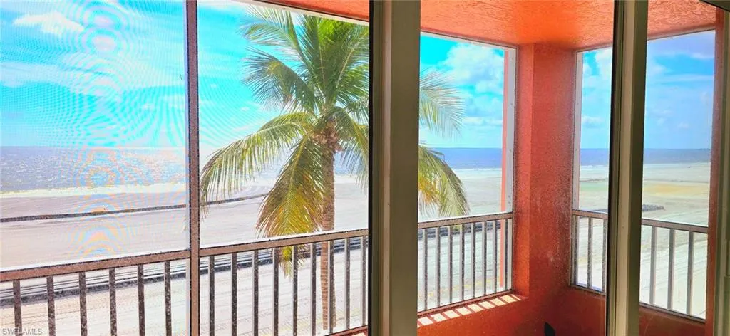 Sunroom with a view of the beach and a water view