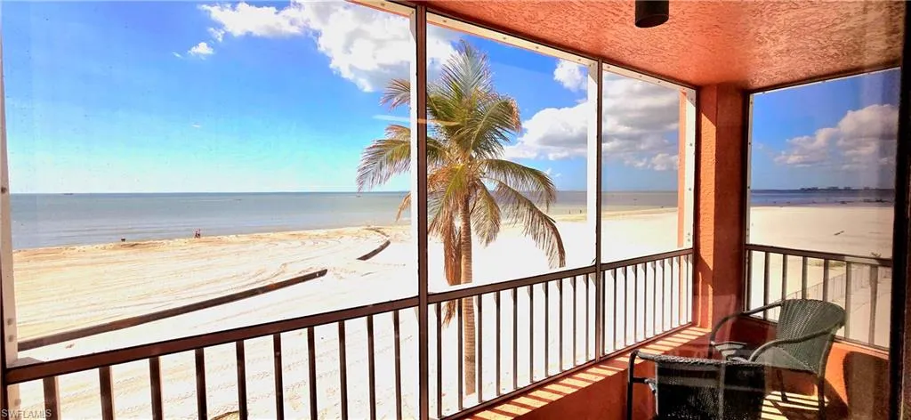 Sunroom / solarium with a beach view and a water view