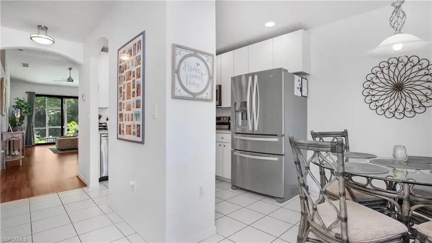 Dining space featuring a ceiling fan, light tile patterned flooring, arched walkways, and recessed lighting