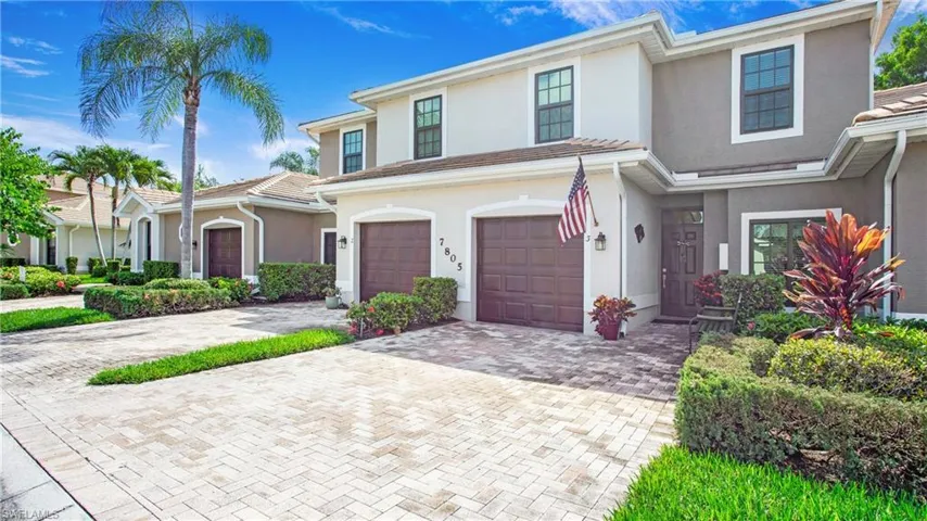 View of front facade with a garage, stucco siding, and driveway