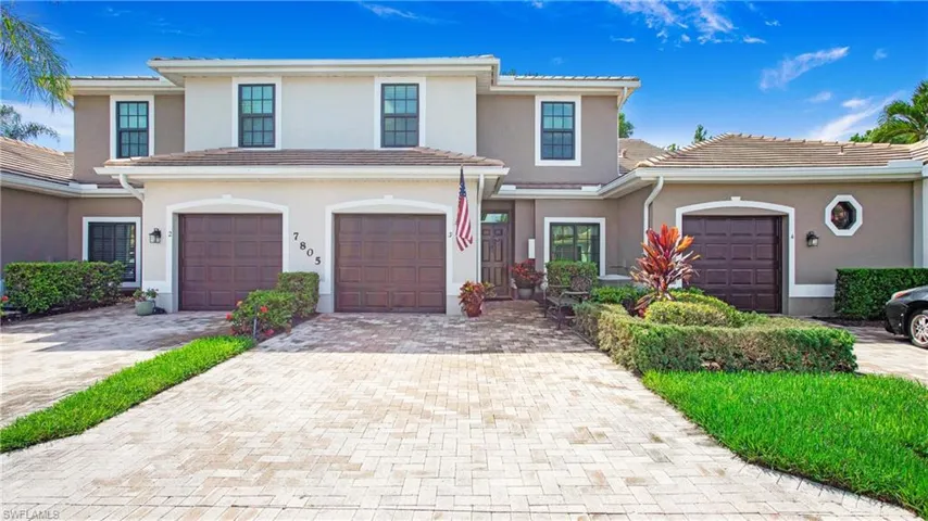 View of front of house with stucco siding, driveway, an attached garage, and a tiled roof