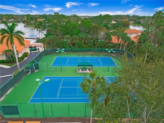 View of tennis court with a water view
