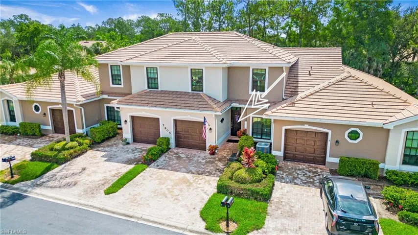 View of front of property with a tile roof, driveway, stucco siding, and an attached garage