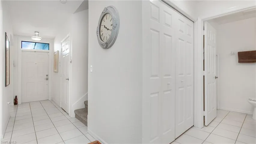 Entrance foyer with light tile patterned flooring and stairs